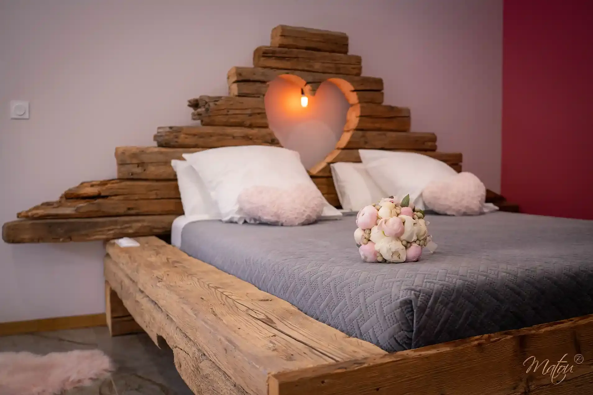 Lit romantique avec tête de lit en bois et bouquet aux Biquettes Amoureuses